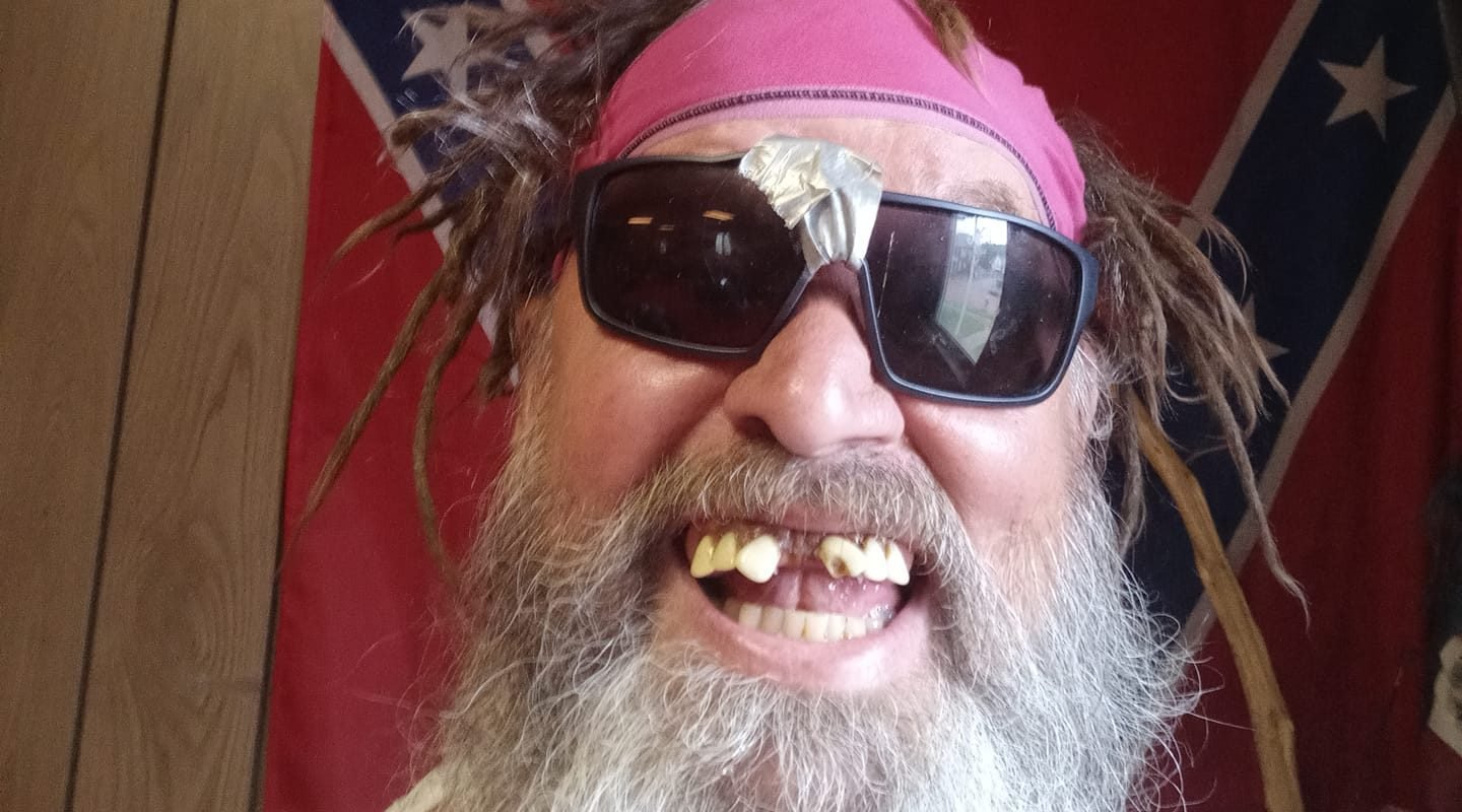 Billy Boofer smiling with sunglasses and pink headband